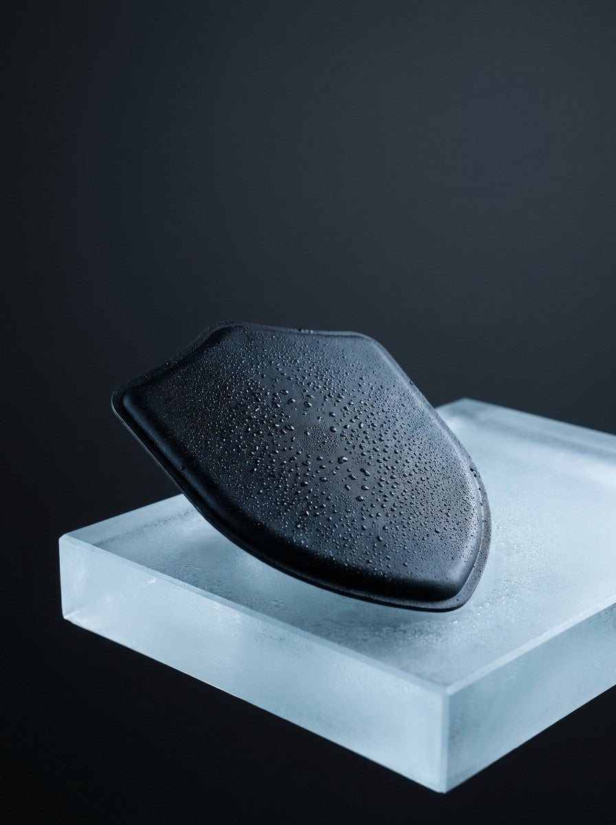 The Sauna Shield Pack resting on a block of ice, condensation beaded across its surface